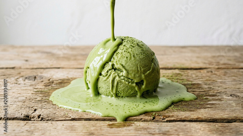 Melting green tea ice cream scoop on rustic wooden table