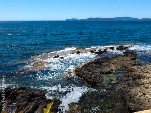 View of Capo Caccia on the horizon, from the promenade along the city walls of Alghero, Sassari, Sardinia, Italy