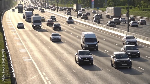 Moscow, July 04, 2026, Busy highway with multiple lanes of traffic. Cars and trucks move steadily in both directions. Sunlight highlights the road surface. Vehicles flow smoothly along the highway