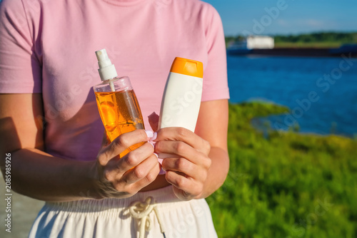 Tableau sur toile Woman offering sunscreen and tanning oil for summer vacation, beach holidays, and everyday UV protection