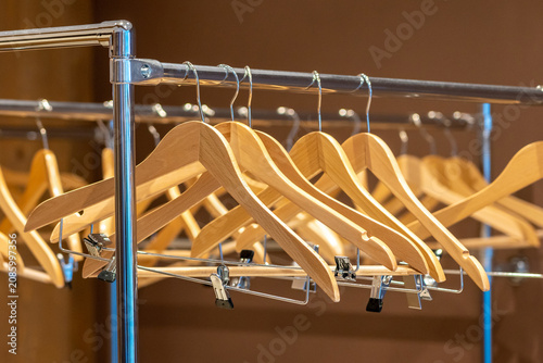 Photos Wooden hangers on coat rack with no clothes in cloakroom or closet