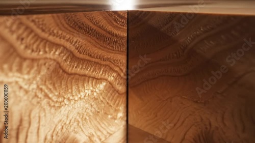 Close-up perspective of a geometric wood surface with varying grains and warm brown tones in natural light