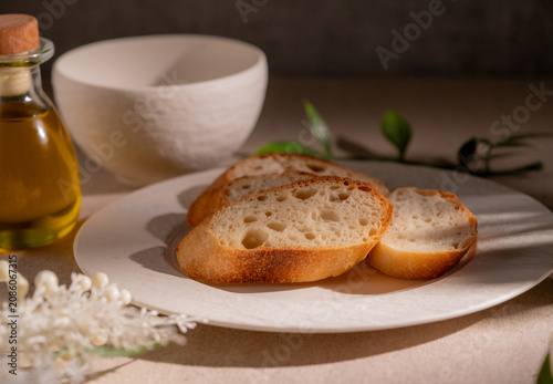 Rustic Sliced Artisan Bread with Olive Oil on White Plate, Cozy Food Photography