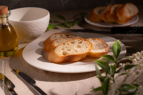 Rustic Sliced Artisan Bread with Olive Oil on White Plate, Cozy Food Photography