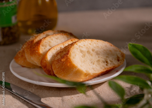 Rustic Sliced Artisan Bread with Olive Oil on White Plate, Cozy Food Photography