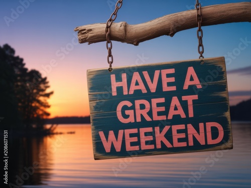 Rustic Wooden Sign Hanging from a Tree Branch with Have a Great Weekend Text over Lake Sunset