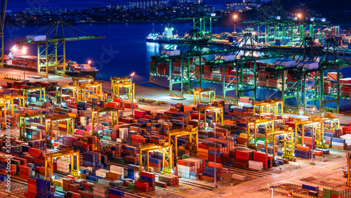 Illuminated high-angle night view of a bustling container terminal and cargo ships at the Port of Singapore