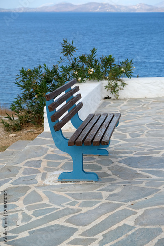 Canvas Print A wooden bench with blue legs against the backdrop of the blue sea on a sunny da