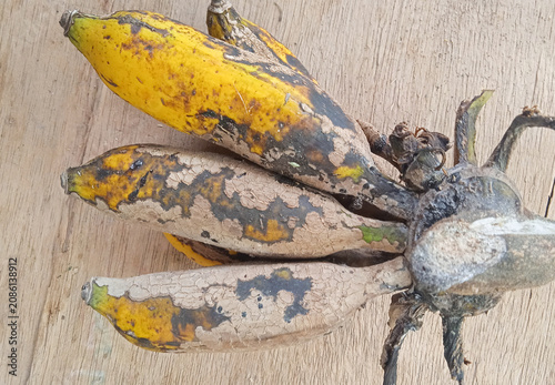 Konstfotografi top view of a small bunch of overripe bananas with black spots on a rustic woode