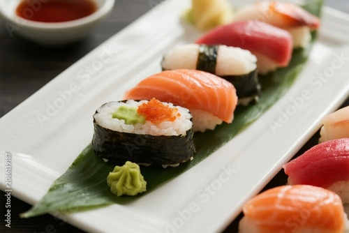 фотографія Assorted sushi pieces arranged on a white plate with wasabi and soy sauce