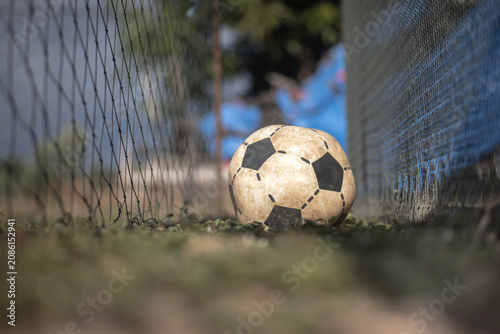 Obraz na plátně Soccer ball on grass near net in outdoor field with blurred background and shall