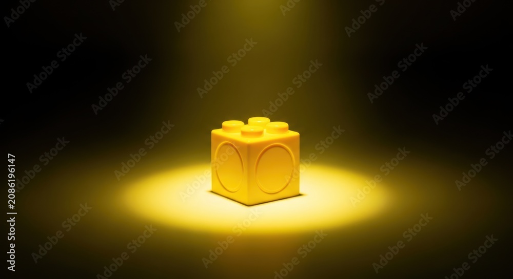 Obraz premium Single Yellow Lego Brick Spotlight.