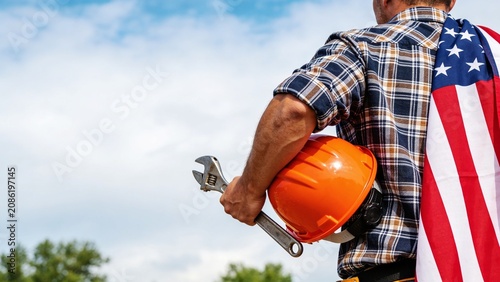 Proud Construction Worker Holding Safety Helmet with American Flag on Labor Day and Wide Copy Space Background