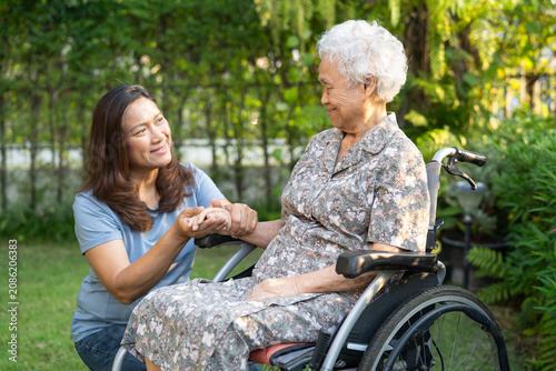 Caregiver help and care Asian senior woman patient sitting on wheelchair at nursing hospital ward, healthy strong medical.