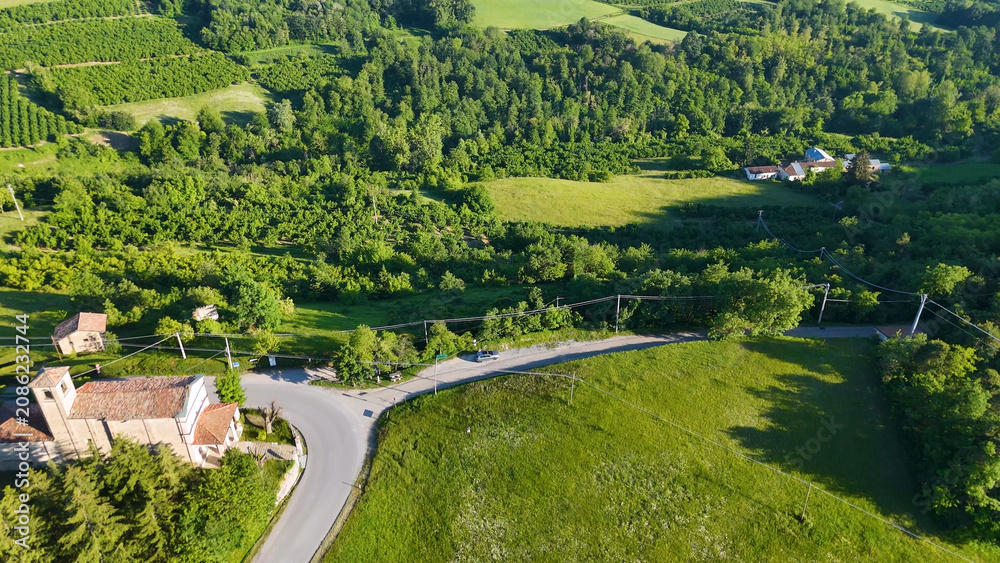 Obraz premium Aerial View of a Historic Church and Winding Road in Piedmont