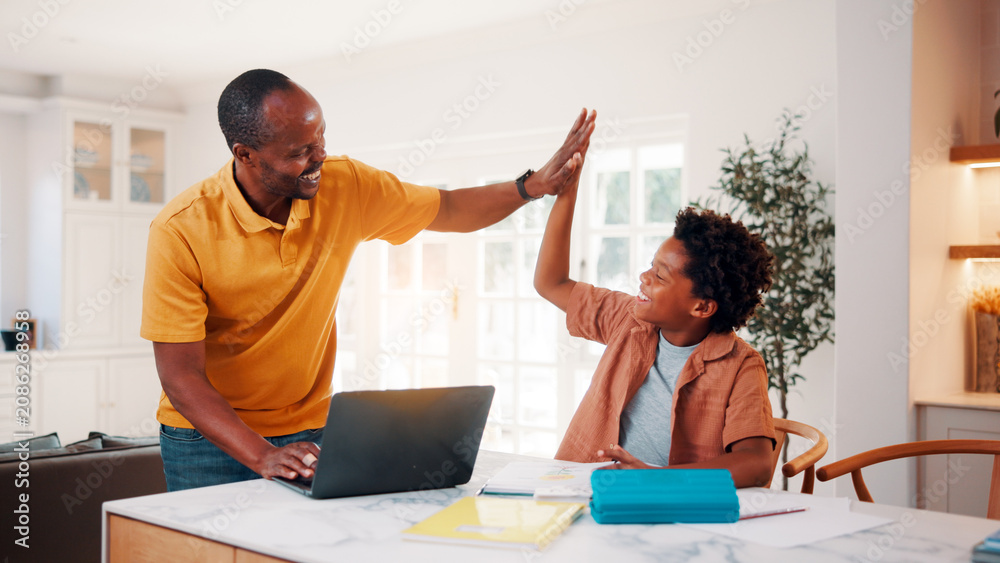 Fototapeta premium Father, child and high five in home with homework, good news or celebration for learning success. Smile, black family or laptop at house with kid, congratulations and achievement for academic results