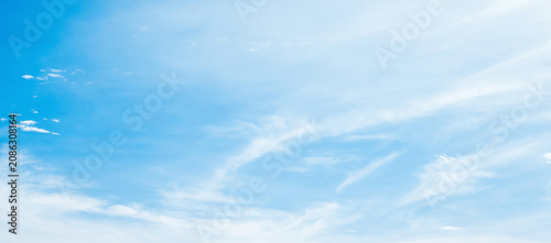 the sky is clear blue with fluffy white clouds, the sky is very bright, and the sun shines.