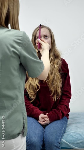 Female practitioner conducting physical examination for a patient in safety hospital ward. Modern healthcare service, prevention and wellness concept. Vertical