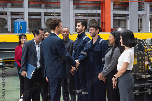 Fotografía Business leader greets factory worker in workwear during industry visit with tea