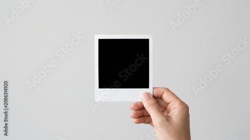 Hand holding blank photo frame