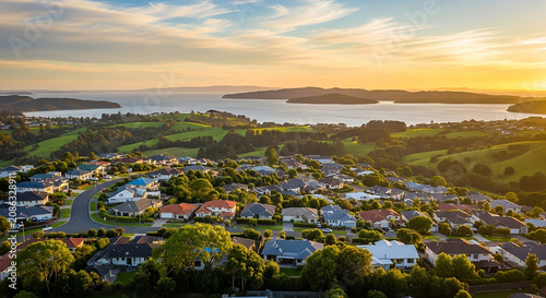 Coastal residential suburb with green hills overlooking blue ocean