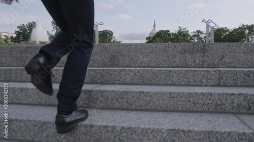 Business man walking stairs for success story. Businessman climbing stairs as motivation symbol. Business man stepping up stairs career ladder. Businessman walking stairs outdoors in city.