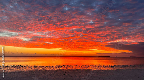 Foto Spectacular sunset paints the tropical coastline with glowing red clouds and gol