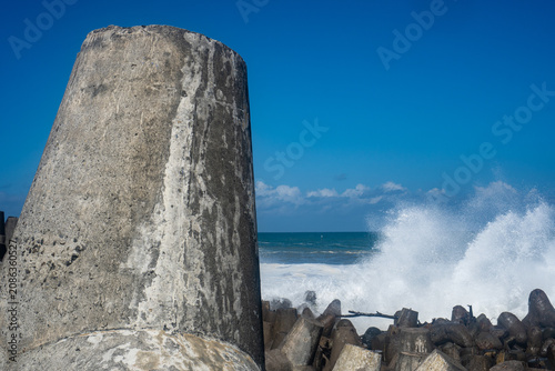 Canvastavla Large coastal wave barrier resisting ocean waves on a sunny day.
