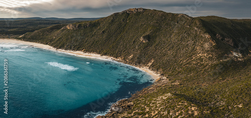 Aerial view of Conspicuous Cliff featuring rugged coastal cliffs, turquoise ocean waters, sandy beach, and dense native vegetation in Nornalup, Western Australia, Australia.