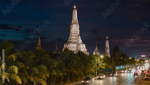 Bangkok Wat Arun Temple at Night with Palm Trees and Traffic
