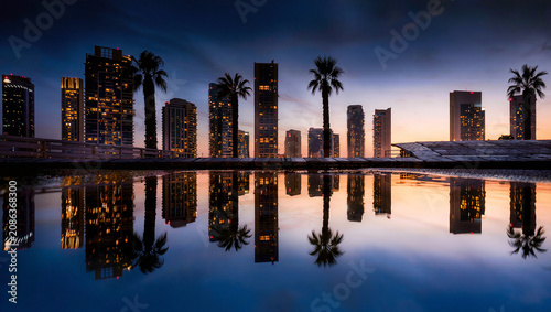 Cityscape reflection at dusk with palm trees and modern buildings
