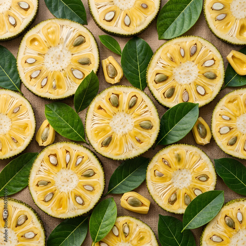 Freshly sliced yellow lemon rounds on green leaves.