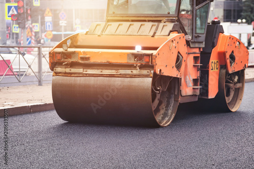 Foto Urban Street Paving With Heavy Machinery During Road Construction on a Busy City