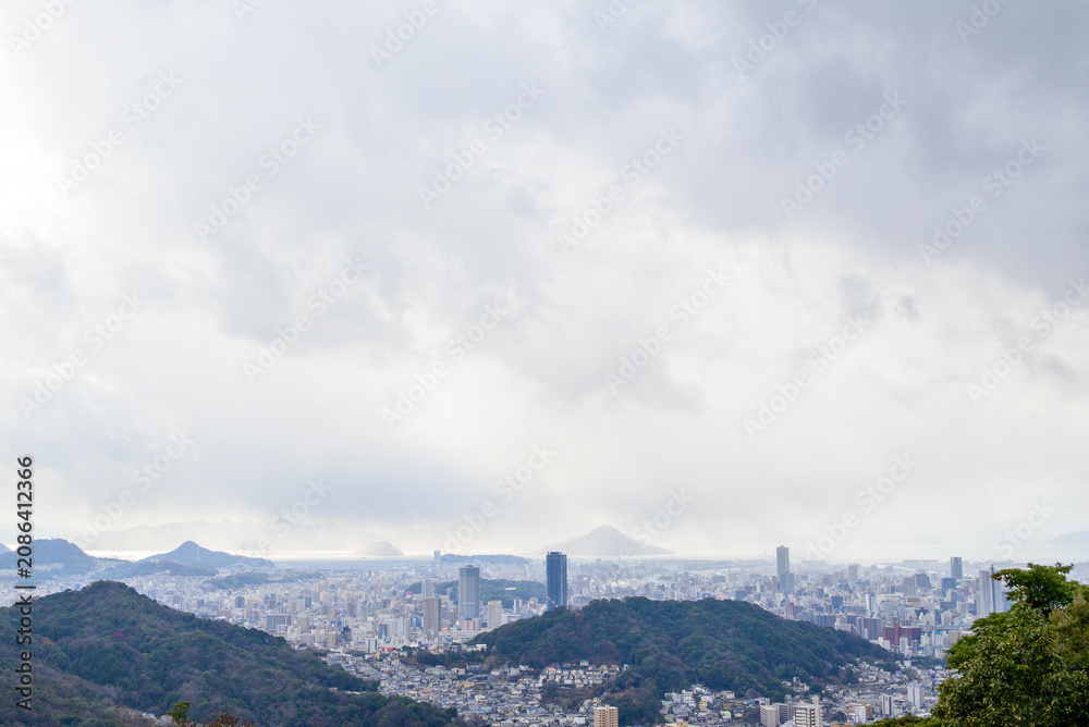 Naklejka premium Panoramic aerial view of Hiroshima city under dramatic cloudy sky