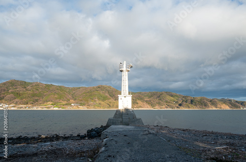 A white lighthouse standing on a pier overlooking the Seto Inland Sea