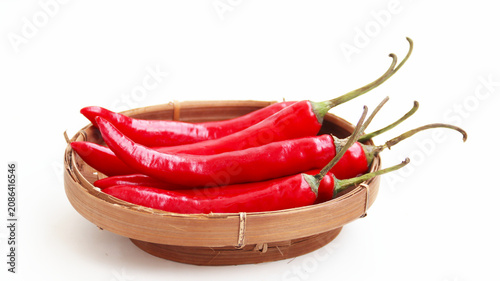 Fényképezés red hot chili pepper on wicker bamboo bowl isolated on white