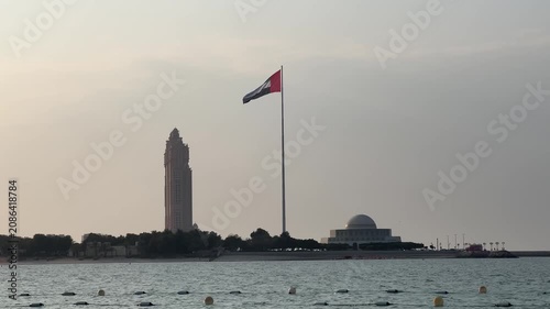 United Arab Emirates flag waving in the sky. Flag in the capital of UAE, Abu Dhabi. Flag of the UAE seen outdoors over the gulf in Dubai.