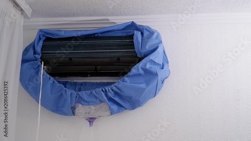 Dirty water draining from an air conditioner unit during professional cleaning and maintenance service
