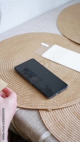 Man's hands cleaning a smartphone display before applying a new screen protector film