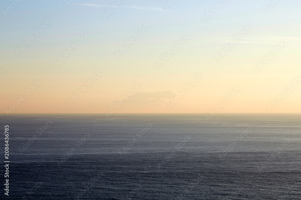 Obraz premium Minimalist view of the calm ocean horizon at sunset