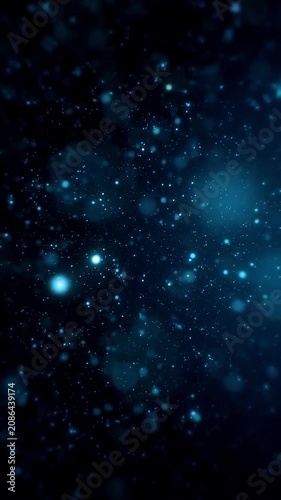 Glowing blue particles floating on a dark background, vertical video featuring elegant light effects, atmospheric motion and futuristic digital energy