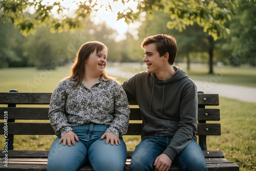 Young man and woman with down syndrome sharing moment on bench