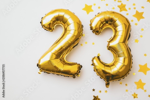Golden 23 balloons celebrating anniversary on white background with stars