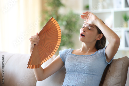 Fotografía Overwhelmed teen fanning suffering heat stroke at home
