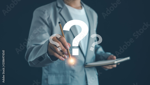 Business professional writing a question mark symbol, representing problem solving, critical thinking, decision making, strategic planning, innovation, research, and finding business solutions.