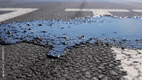 Close up view of black asphalt melting on a desert road under extreme heat.