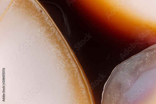 Close-up abstract view of a polished agate slice showing swirling bands of color and texture.
