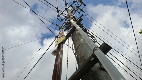 Power pole silhouette with cables against overcast sky
