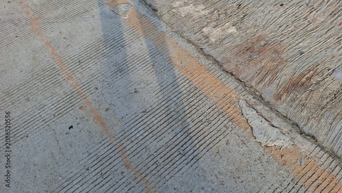 Reflective wet asphalt surface with diagonal shadow