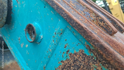 Rusted hinge mechanism on turquoise metal panel